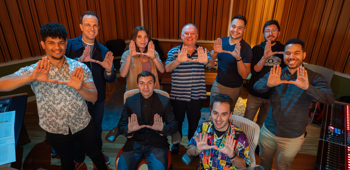 larger image of individuals with the UM hands up with the U hands showing